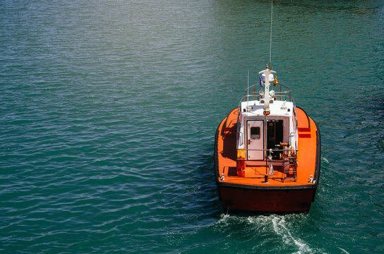 Bright orange pilot boat navigating the ocean waters