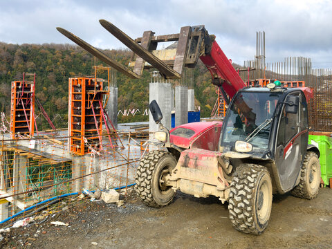 Forklift at a construction site with mountain background
