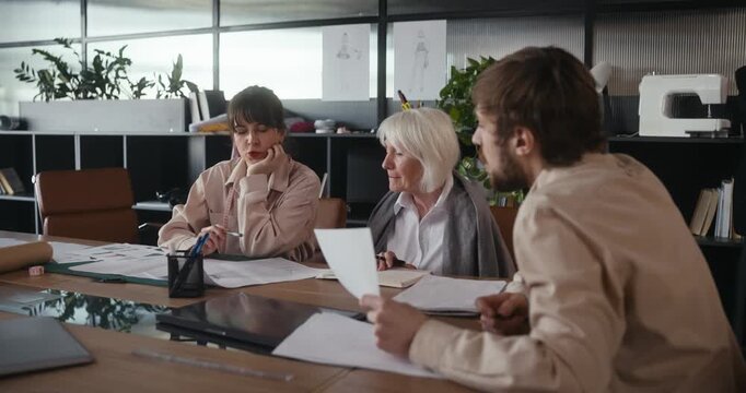 Three talented designers collaborate on innovative ideas in a sleek office space filled with greenery