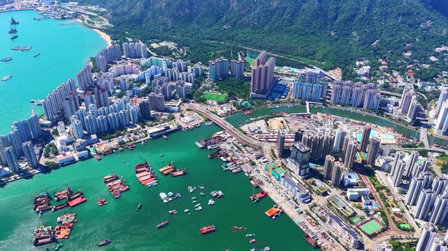 Aerial skyview of Tuen Mun subway extension project in Hong Kong, featuring elevated railway construction along Tuen Mun River and road, new station development and temporary work platforms