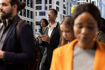 Fototapeta premium Indian male entrepreneur navigating on his phone through busy city street, showing urban crowd, pedestrians and dynamic activity. Everyday business lifestyle in modern metropolitan environment.