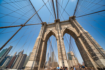 Fototapeta premium New York City, NY - June 12, 2025: Brooklyn Bridge architectural elements with steel cables and stone towers in Manhattan