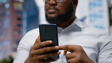 Adult man moves through metropolitan sidewalk with confidence, checking his navigation and gps on...