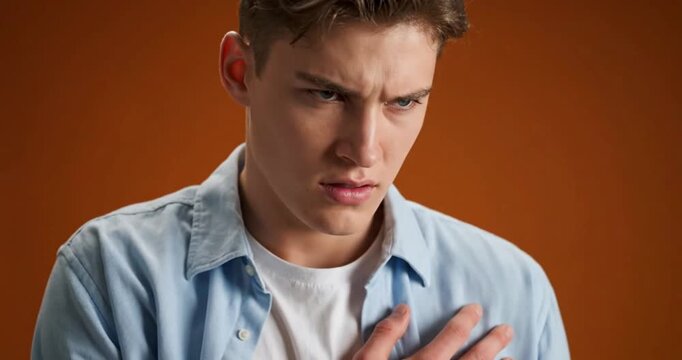 Young Man Expressing Jealousy and Emotional Insecurity in Studio Portrait
