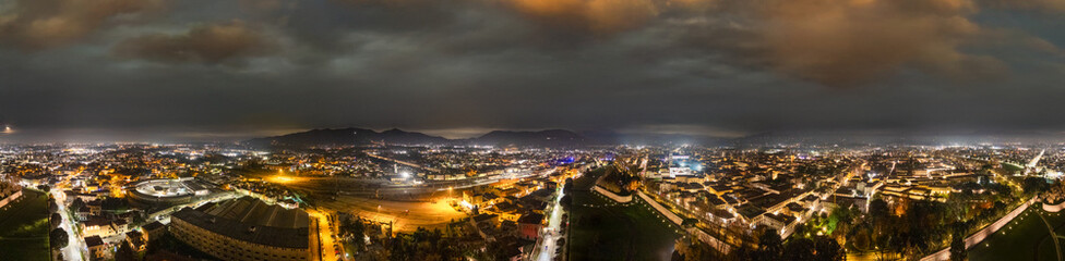 Naklejka premium Panoramic aerial night view of Lucca showing illuminated streets and historic architecture