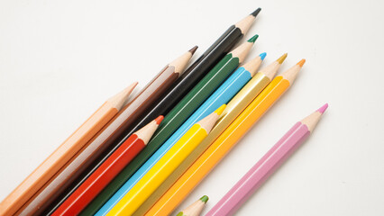 Fototapeta premium A row of pencils with different colors, including red, yellow, green, and blue