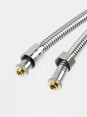 Flexible shower hose close-up. Metallic, chrome-plated, shiny.