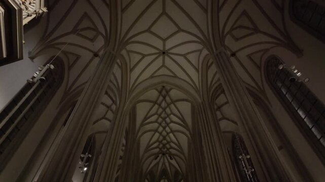 Slow motion cinematic view of the Gothic ribbed vault ceiling in St. James Church, Brno, at night