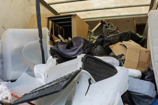Overfilled removal truck with mixed household waste and junk
