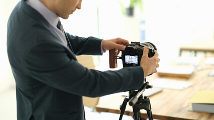 A skilled photographer adjusts his camera on a tripod in a bright, inviting workspace. Sunlight streams through windows, highlighting a creative atmosphere filled with ideas and potential.