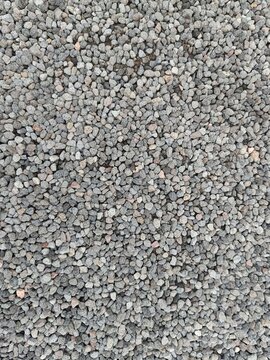 Top view of small gray crushed stone gravel. Natural pebble texture for landscaping, garden pathways, construction backgrounds, and outdoor drainage design concepts.