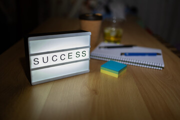 Success light box illuminating modern workspace desk
