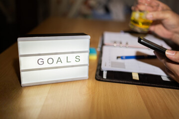 Goals lightbox illuminating desk with planner and smartphone