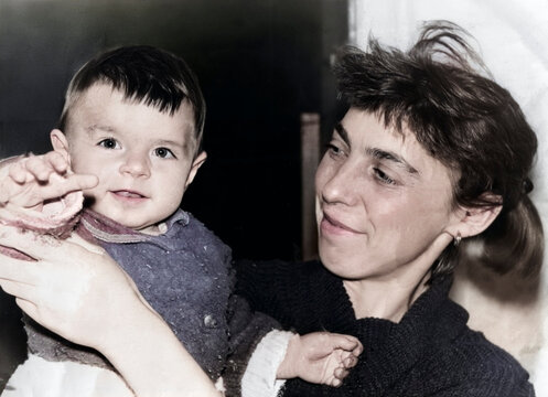 A vintage portrait of a mother and daughter. The happy mother holds her baby in her arms. Retro photo from 1995.