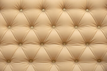 Fototapeta premium Beige leather upholstery with tufting pattern and decorative buttons background