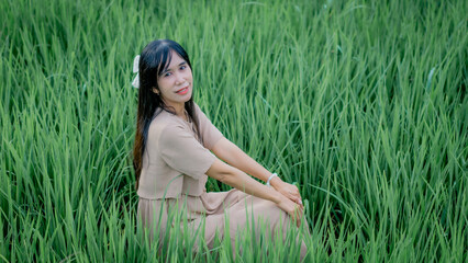 Asian woman do solo traveling to a rice field, enjoying the scenery and fresh air in the village.