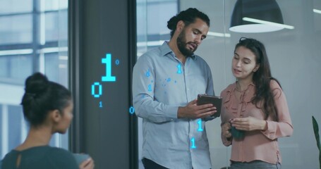 Reviewing team standing in office near glass wall, using tablet and holding mug with binary code