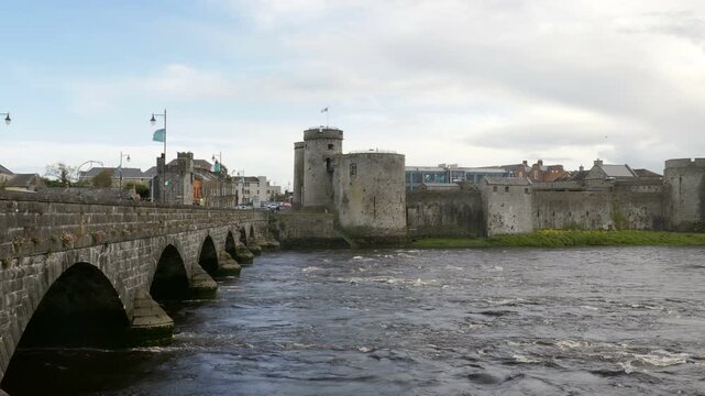 King John's Castle as seen from across the River Shannon with Thomond Bridge crossing over it in Limerick, Ireland. 2019.