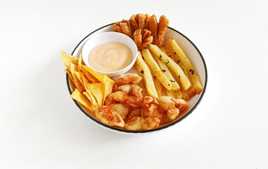Minimalist food photography of mix platter served on a white plate. The dish features crispy fried shrimp, French fries, fried crackers, and corn chips, accompanied by dipping sauces.
