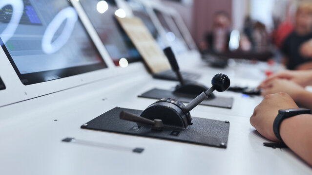 Person operating power levers in a modern flight simulator control panel