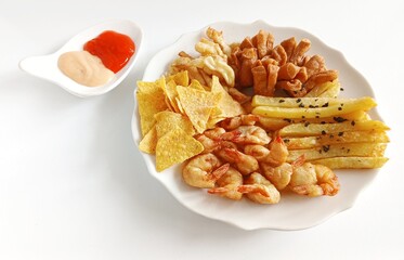 Minimalist food photography of mix platter served on a white plate. The dish features crispy fried shrimp, French fries, fried crackers, and corn chips, accompanied by dipping sauces.