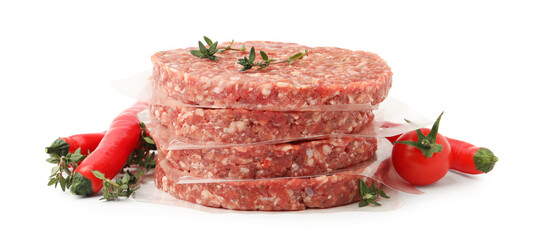 Uncooked meat patties with thyme, chili peppers and tomato isolated on white