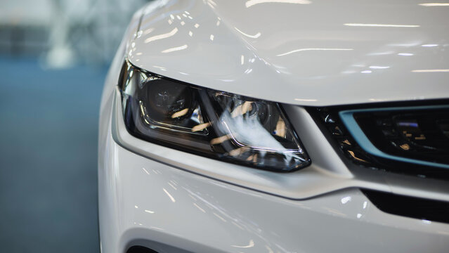 White car headlight close up showing modern vehicle design and technology
