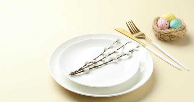 Easter celebration. Woman setting table for festive dinner on beige background, closeup