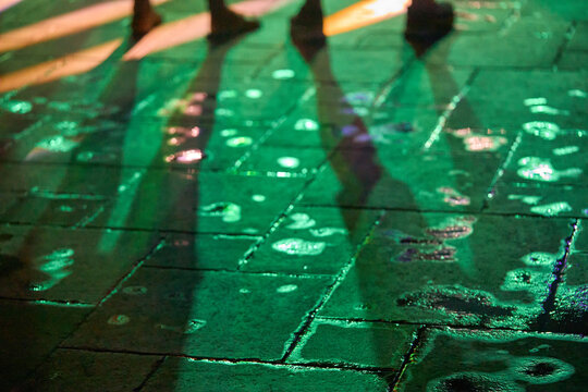Nightlife dancing people backlit by neon lights on dance floor
