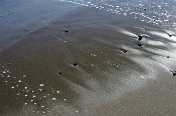 冬の浜辺。誰も居ない海を独り占めしている私。至上の解放感を味わっている。潮が引いたり寄せたり、そのたびに宝石のような小石や貝殻が、行ったり来たり波打ち際をさまよっている。眺めているだけで楽しい気分になった。幾分傾きかけた太陽の光が砂浜を照らしている。砂が作る不思議な紋様。あたかも地球上の広大な平原を眺めているようだ。時を忘れて浜辺で戯れている私。至福の時。