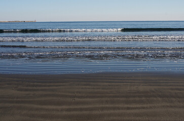 冬の浜辺。誰も居ない海を独り占めしている私。至上の解放感を味わっている。潮が引いたり寄せたり、そのたびに宝石のような小石や貝殻が、行ったり来たり波打ち際をさまよっている。眺めているだけで楽しい気分になった。幾分傾きかけた太陽の光が砂浜を照らしている。砂が作る不思議な紋様。あたかも地球上の広大な平原を眺めているようだ。時を忘れて浜辺で戯れている私。至福の時。