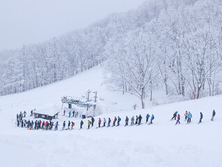 Queue of people waiting for the pizza box ski lift during winter in Nagano, Japan