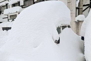 Heavy winter snowfall covering a parked vehicle in the ski resort town of Madarao