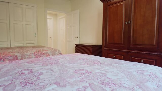 guest room featuring twin beds and a large wooden wardrobe