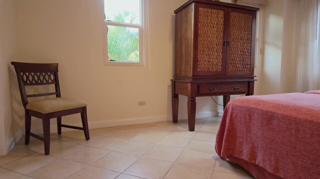 guest room featuring a large wooden armoire, twin beds, and a tropical garden view