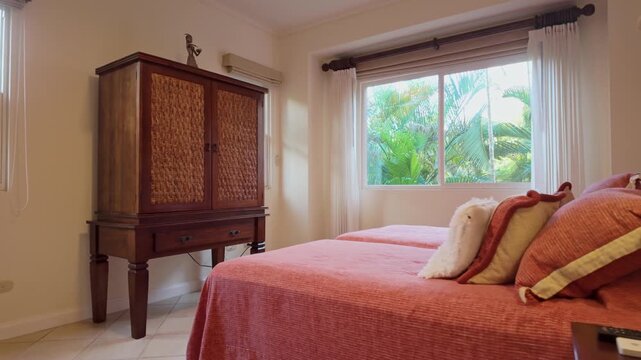 hotel guest room featuring twin beds, a wooden armoire, and a decorative bedside lamp