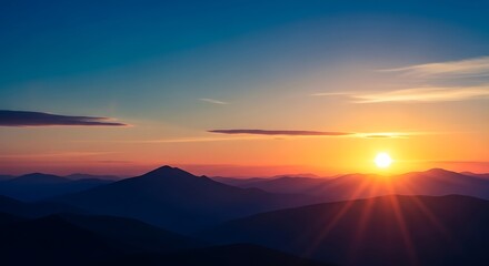 Fototapeta premium Sunset over a mountain range with a clear blue sky and vibrant orange hues