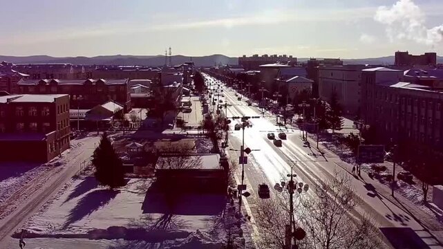 A captivating time-lapse video capturing the dynamic flow of traffic on a main road in a typical small city in Northern China. As daylight fades, vehicle headlights and street lamps create vibrant str