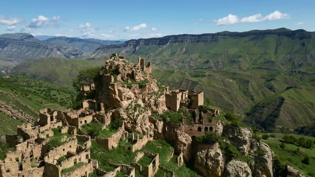 Drone aerial view of the abandoned mountain village of Gamsutl in Dagestan at sunrise with soft morning light and dramatic scenery.