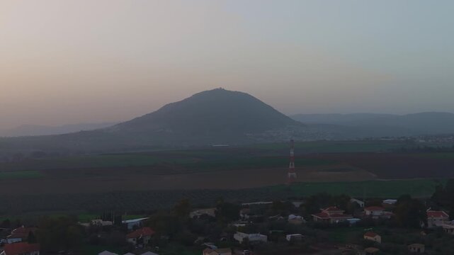 Mount Tabor in Israel features the iconic Franciscan church overlooking the sunset and Kfar Kish fields.