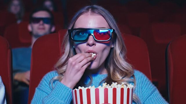 Woman with popcorn at a 3D movie.