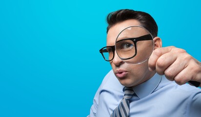 Curious young man with magnifying glass