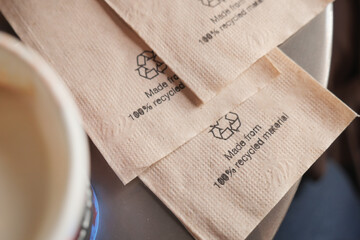 Recycled napkins placed on a table near a coffee cup