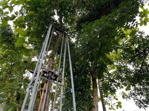 Upper section of water well drilling tower viewed from below, highlighting metal framework, height, and industrial function in outdoor setting.