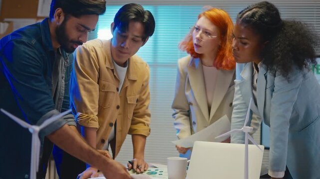 multi-ethnic business people intensely brainstorm focus on monitor,paperwork to strategy for pivotal ESG business shift and agile transformation in office night meeting.ESG policy,volunteer concept