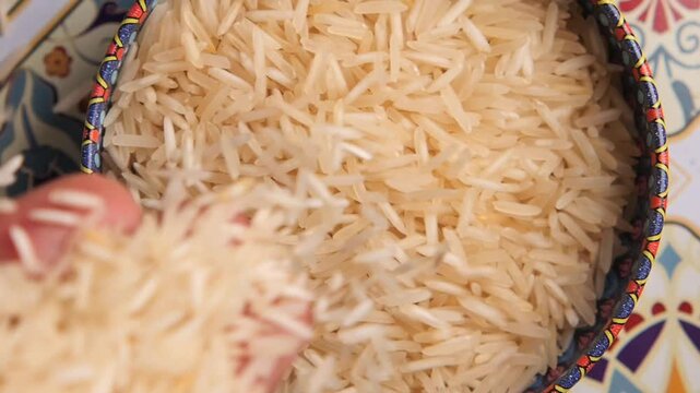 Choosing rice from a bowl for cooking