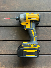 cordless power drill with battery on wooden table