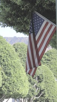 Vertical reel video showing the city flag of Glendora California flying outdoors, capturing a civic symbol within a calm urban environment.