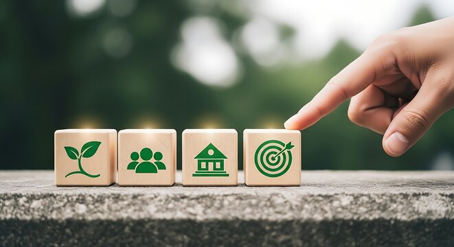 Finger pointing to a row of wooden cubes with green symbols for ESG principles: ecology, society, corporation, and objectives.