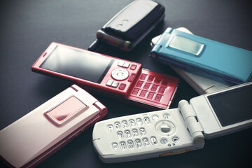 黒い背景に置いたひと昔前のガラケイの携帯電話